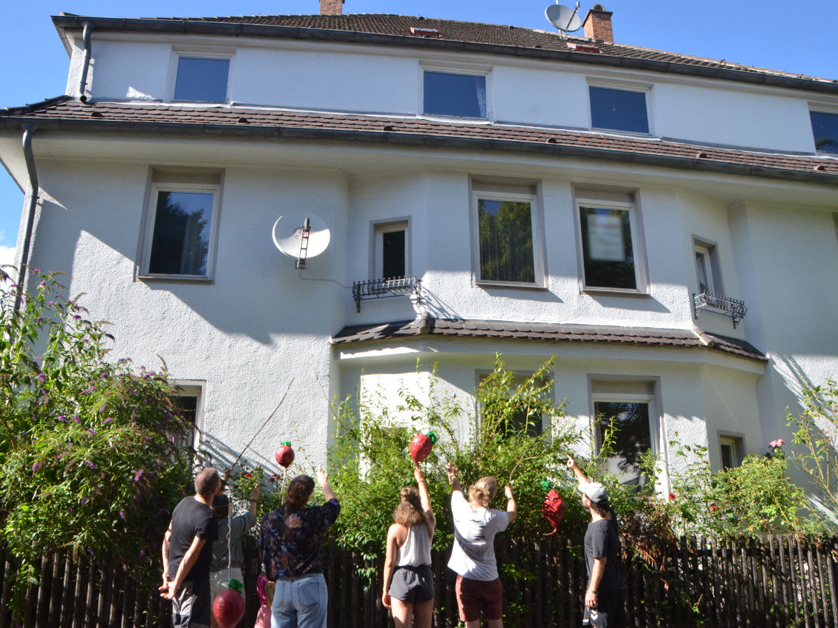 Menschen vor einem Haus mit Mansarddach