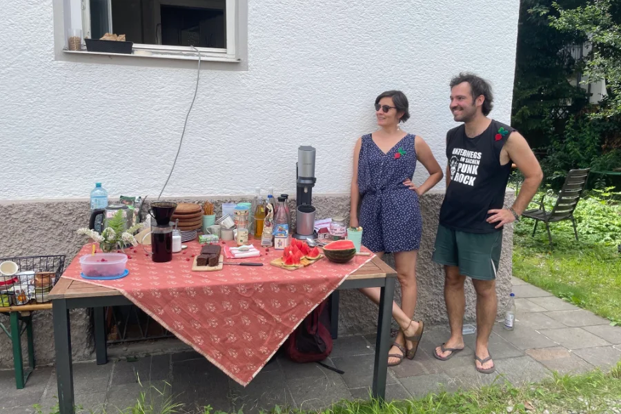 Einladende Menschen an einem Biertisch Kaffee und Kuchen